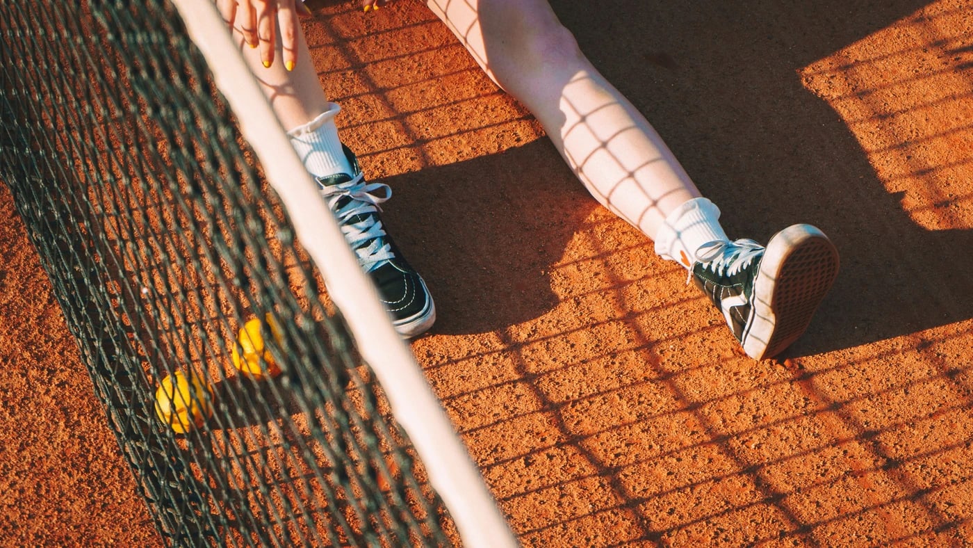 Pista de tenis vista a través de la valla